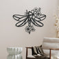 Decorative metal wall art of a dragonfly with floral elements on a wall.