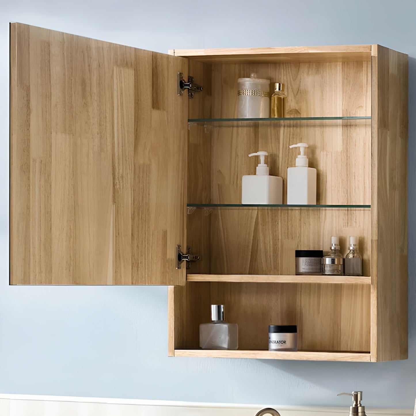 Wooden cabinet with open door displaying various bottles and containers against a light blue wall.