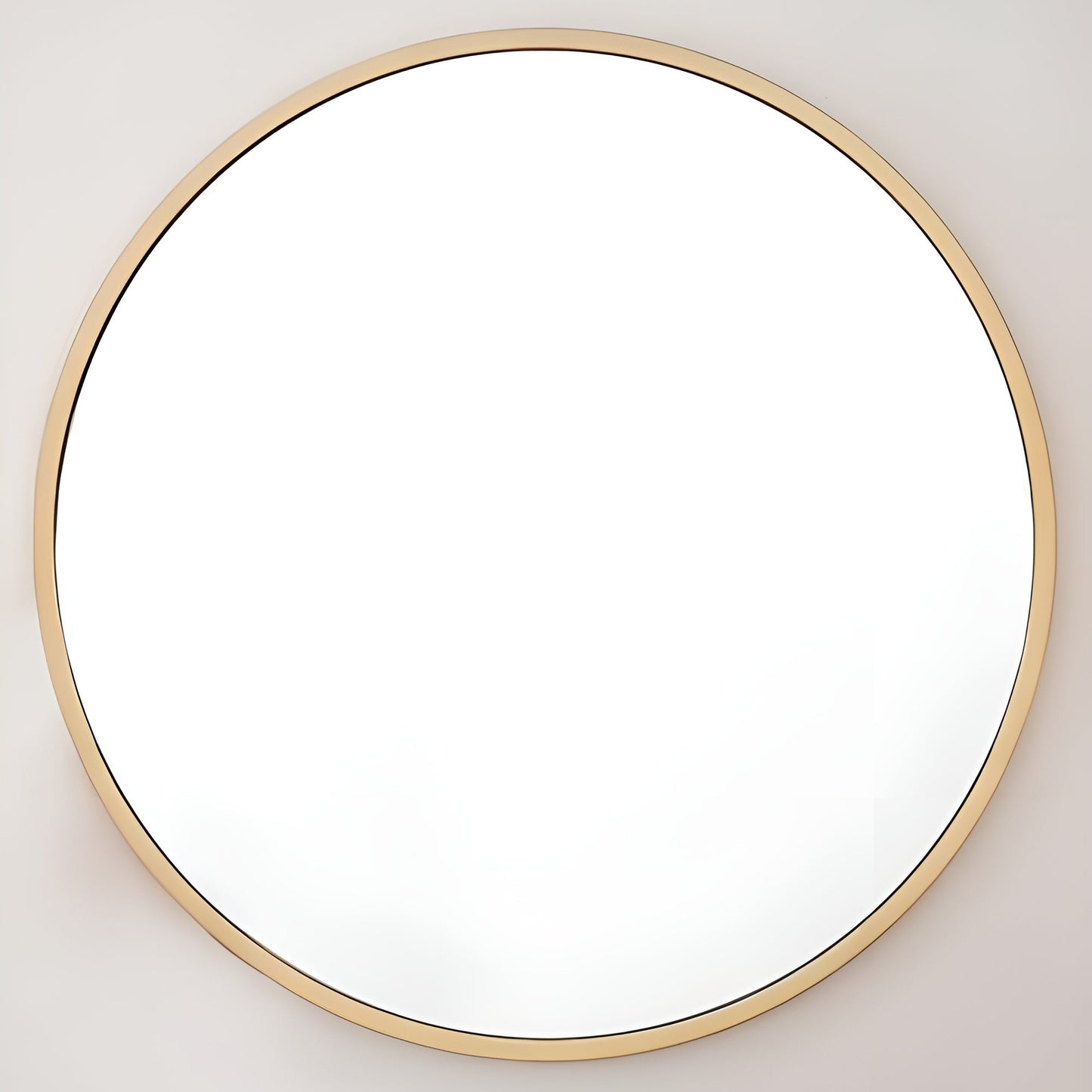 Round mirror with a gold frame on a light gray wall