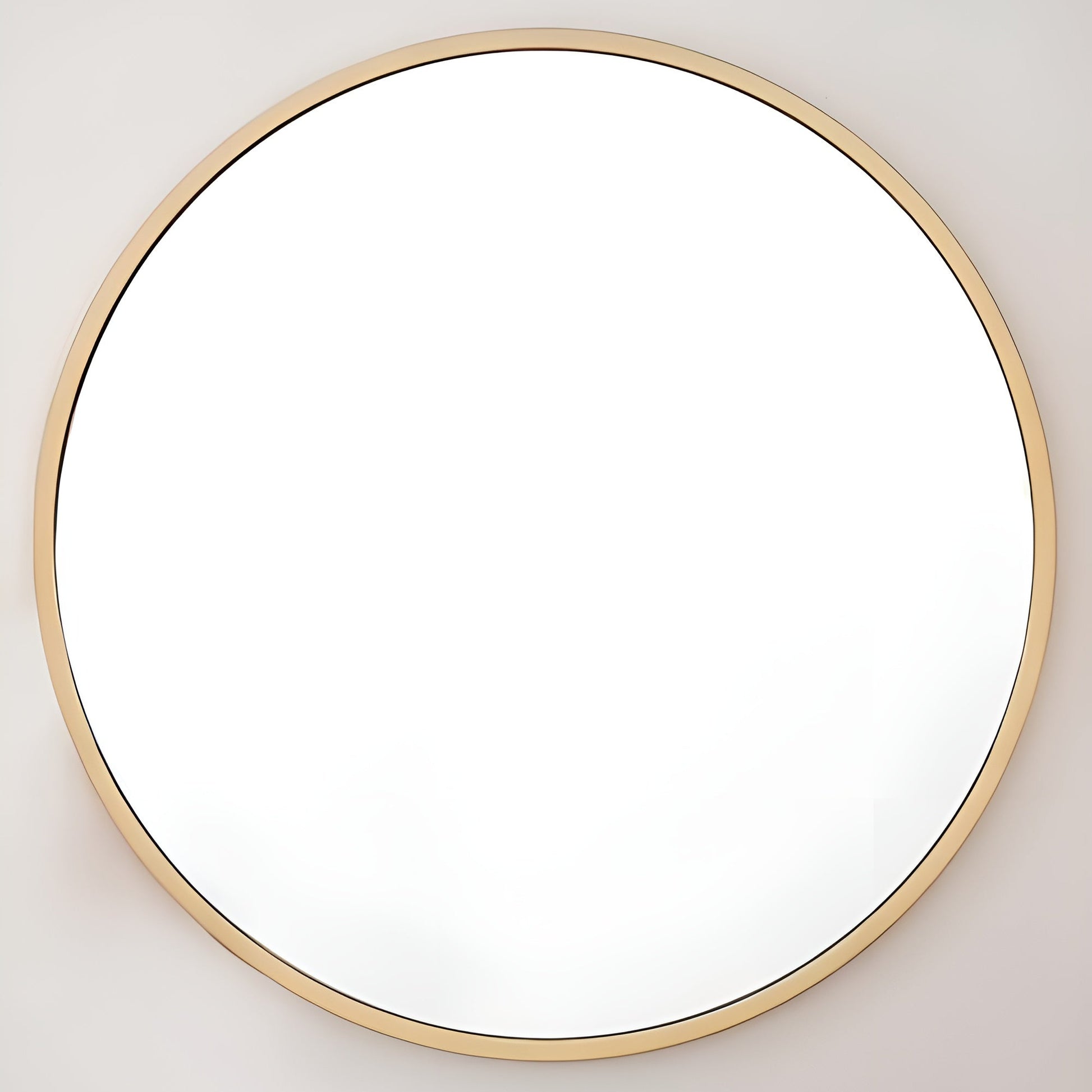 Round mirror with a gold frame on a light gray wall