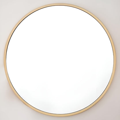 Round mirror with a gold frame on a light gray wall