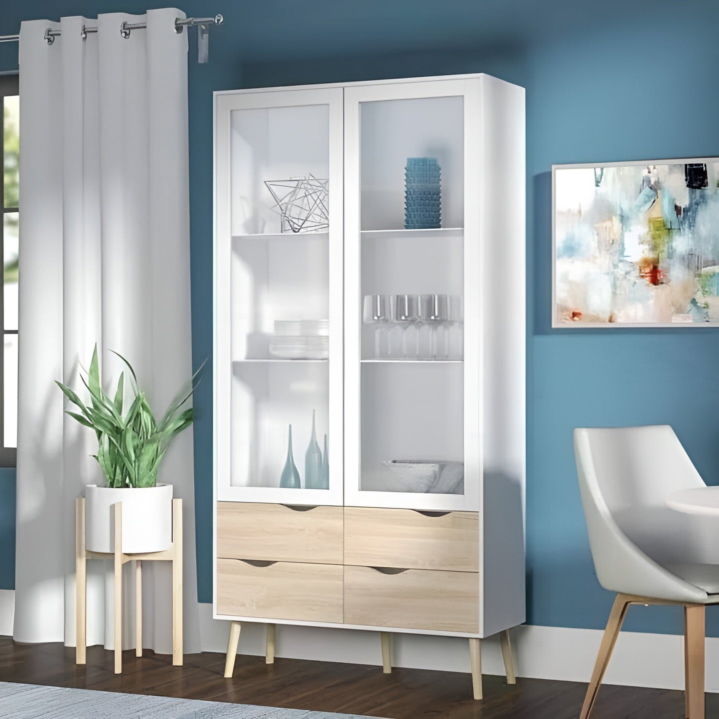 White display cabinet with glass doors in a room with blue walls, a chair, and a plant.