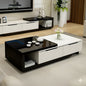 Modern living room with a black and white coffee table, TV, and decorative items.