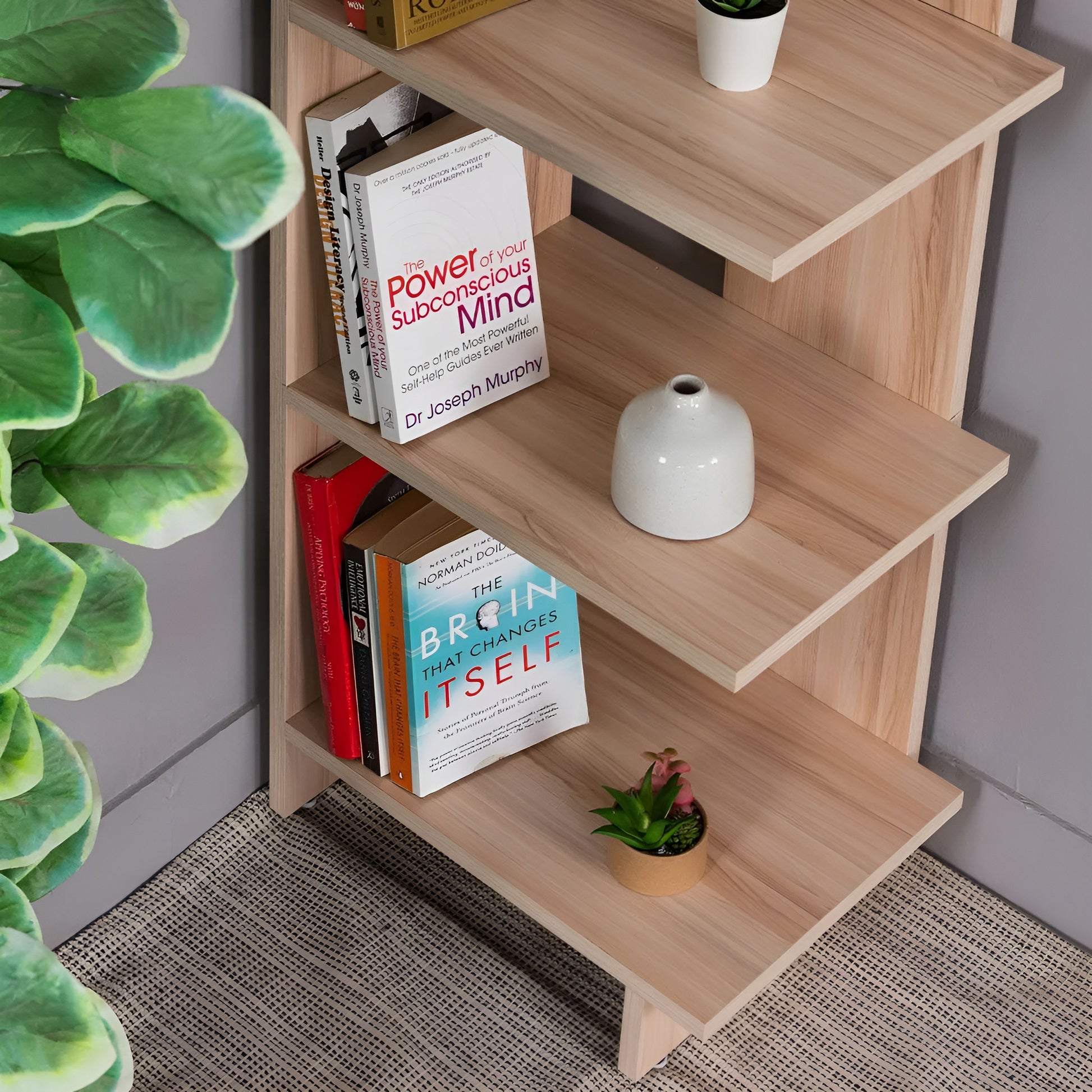 Wooden bookshelf with books and decor items against a gray wall.