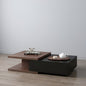 Modern coffee table with wooden and black design, featuring a teapot and decorative items on a plain background.