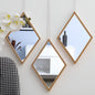Hexagonal mirrors with wooden frames on a white wall, reflecting interior decor.