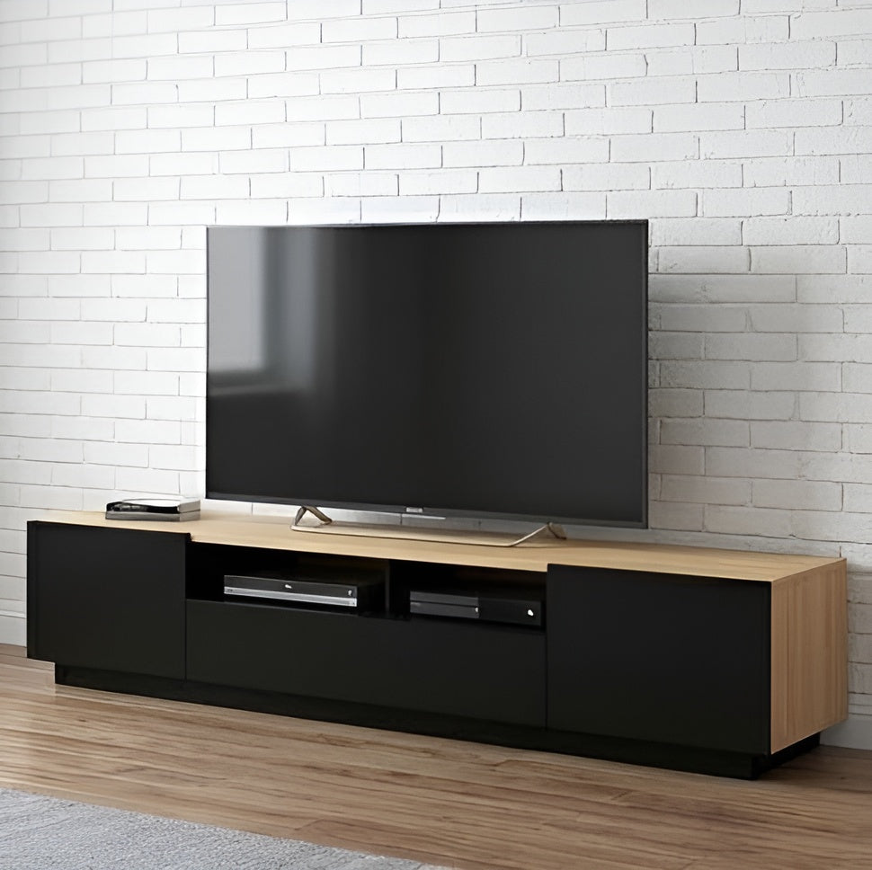 Modern TV stand with a large flat-screen TV against a white brick wall.
