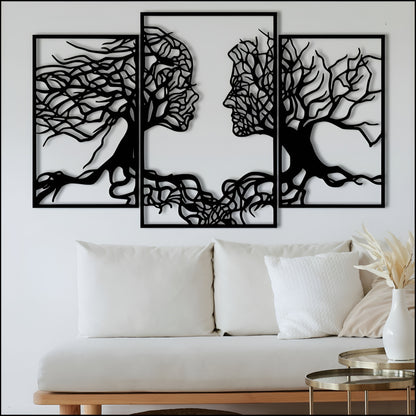 Three black abstract wall art pieces on a white wall above a white sofa.