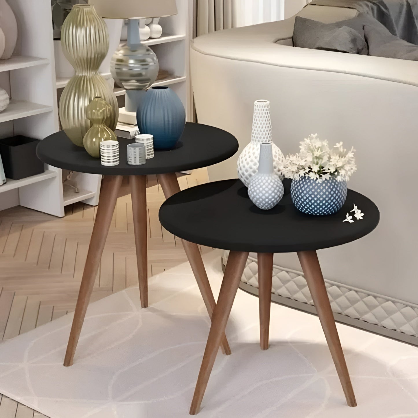 Two black side tables with wooden legs in a living room setting.