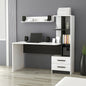 White and black L-shaped desk with shelves and a laptop in a room setting.