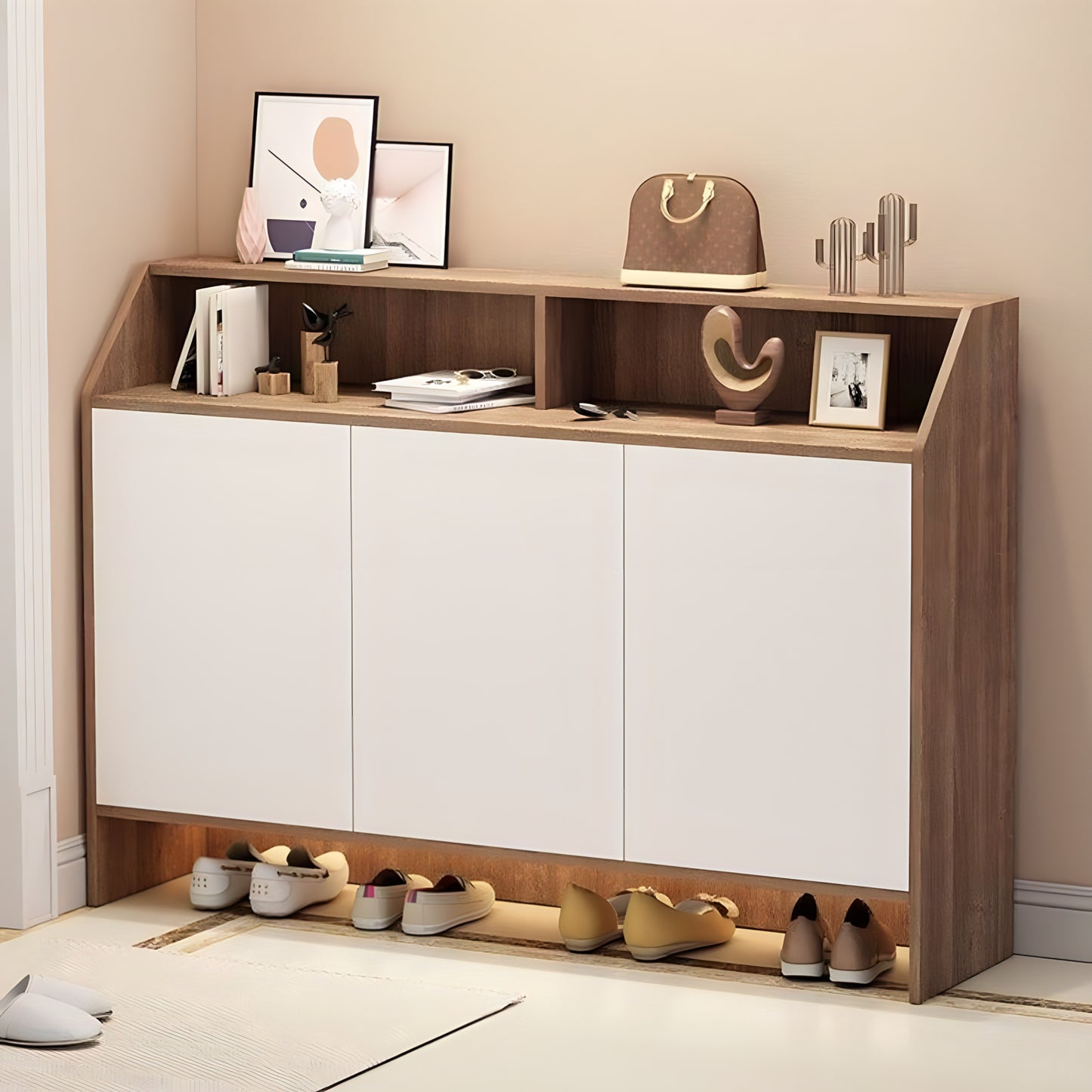 Shoe cabinet with shoes underneath and decorative items on top in a room.
