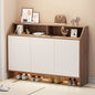 Shoe cabinet with shoes underneath and decorative items on top in a room.