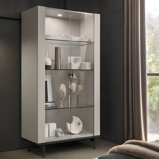 Modern glass display cabinet against a dark wall with decorative items inside.