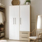 White wardrobe with wooden accents in a room with a chair and shelves.