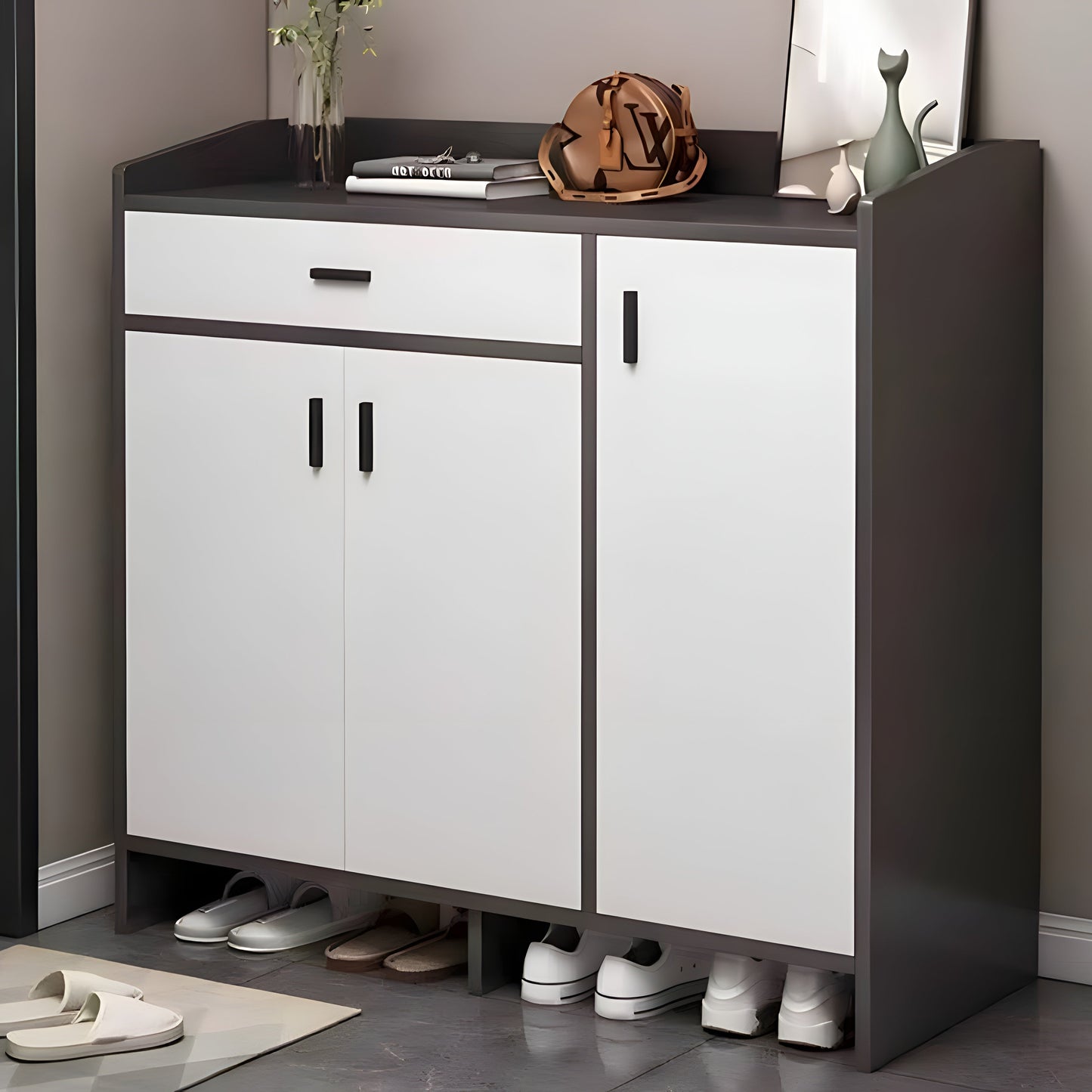 White shoe cabinet with black top and sides, shoes underneath, on a gray floor.