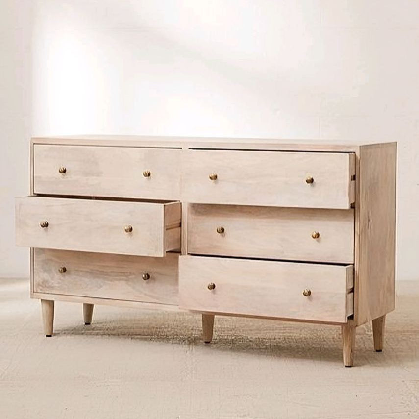 Light wooden dresser with multiple drawers on a plain background