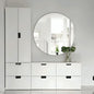 White dresser with round mirror in a minimalistic room