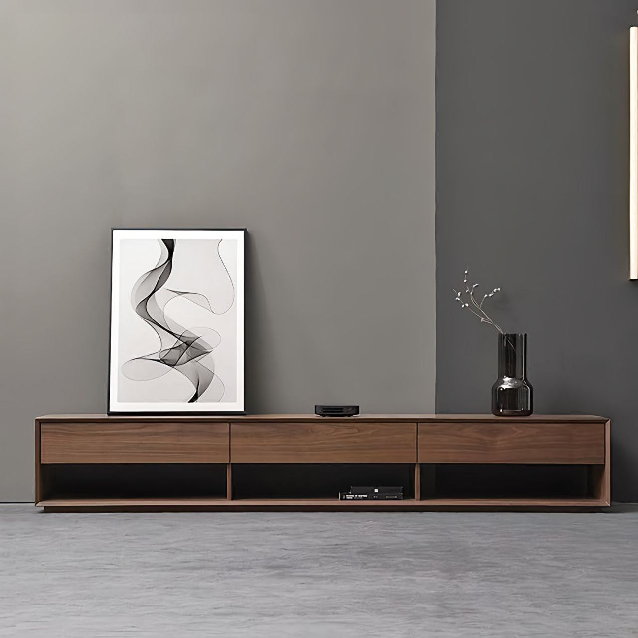 Modern living room with wooden TV stand, abstract art, and vase against a gray wall.