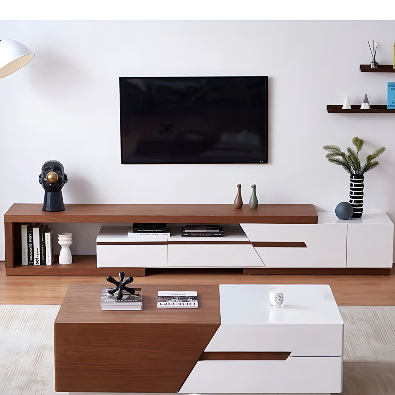Modern living room with wooden and white entertainment console, TV, and decor items.