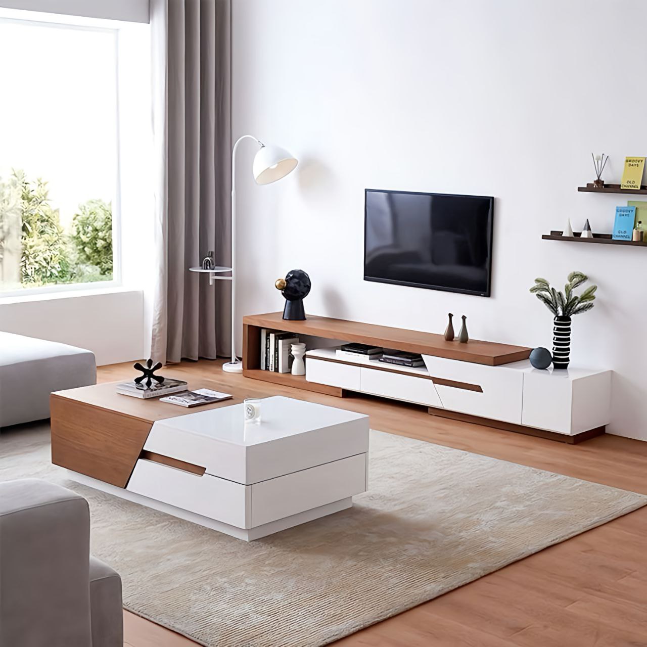 Modern living room with a white and wood entertainment console, coffee table, and decor items.