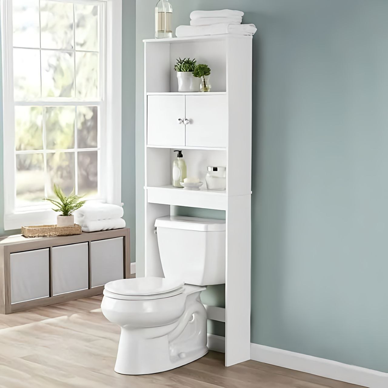 White over-the-toilet storage cabinet with shelves in a bathroom setting.
