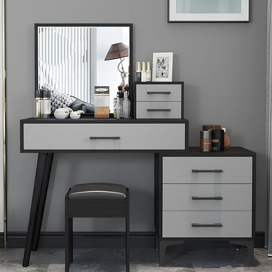 Dressing table with mirror, drawers, and stool against a gray wall.