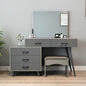 Gray vanity with mirror, drawers, and stool in a room setting.
