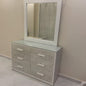 Dresser with mirror on a beige wall and tiled floor